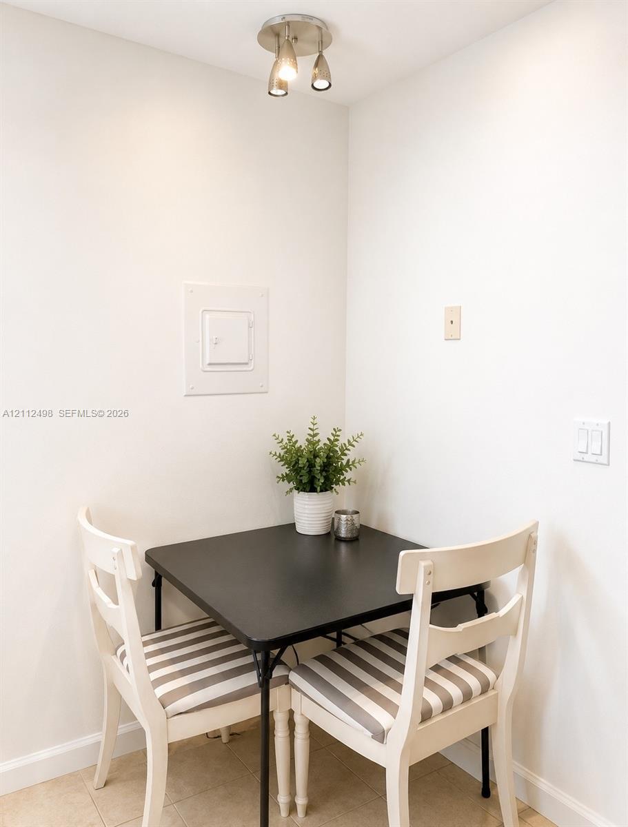 Neutral-toned interior wall finish, brushed nickel three-light adjustable ceiling fixture, and tile flooring
