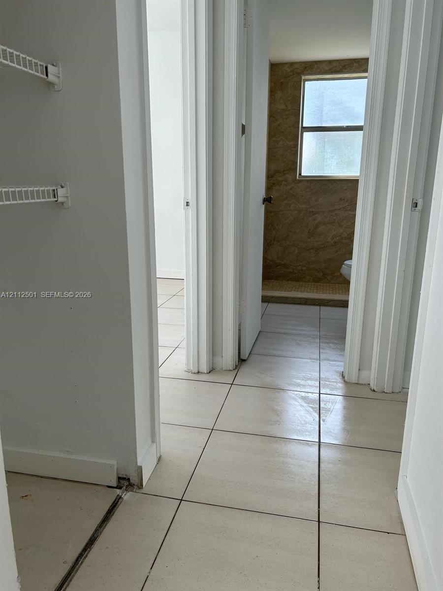 Ceramic tile flooring throughout with wall-mounted wire shelving units Ceramic tile flooring throughout with wall-mounted wire shelving units