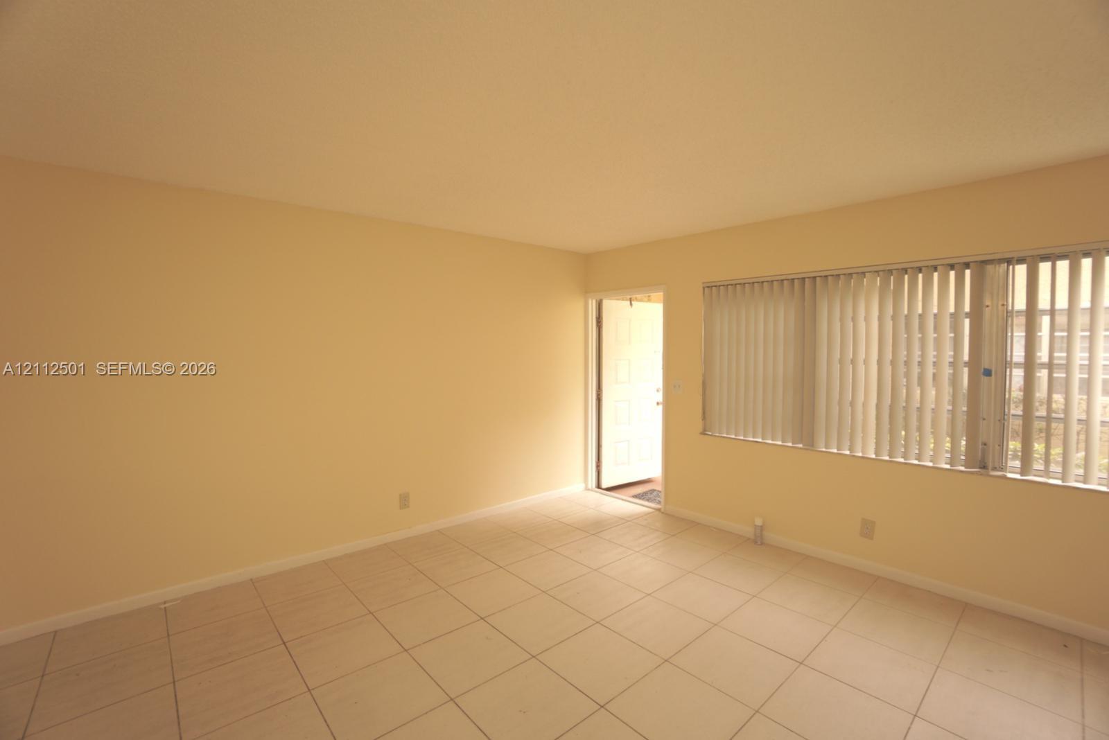 Interior space featuring neutral wall paint, large format tile flooring, and a multi-paneled door
