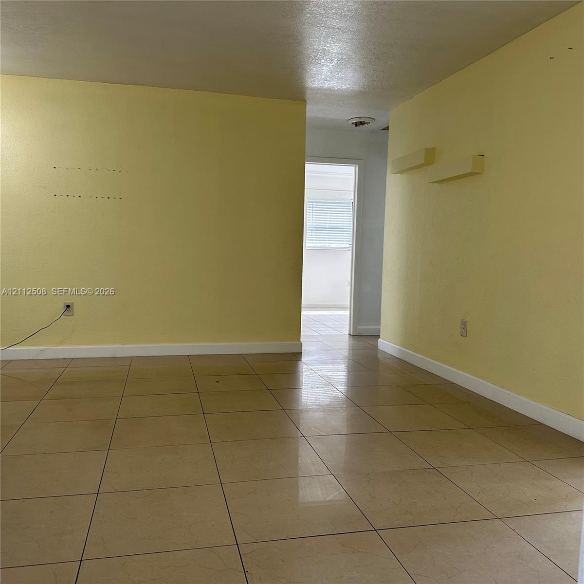 Interior space featuring large-format neutral tile flooring and smooth-finish walls Interior space featuring large-format neutral tile flooring and smooth-finish walls