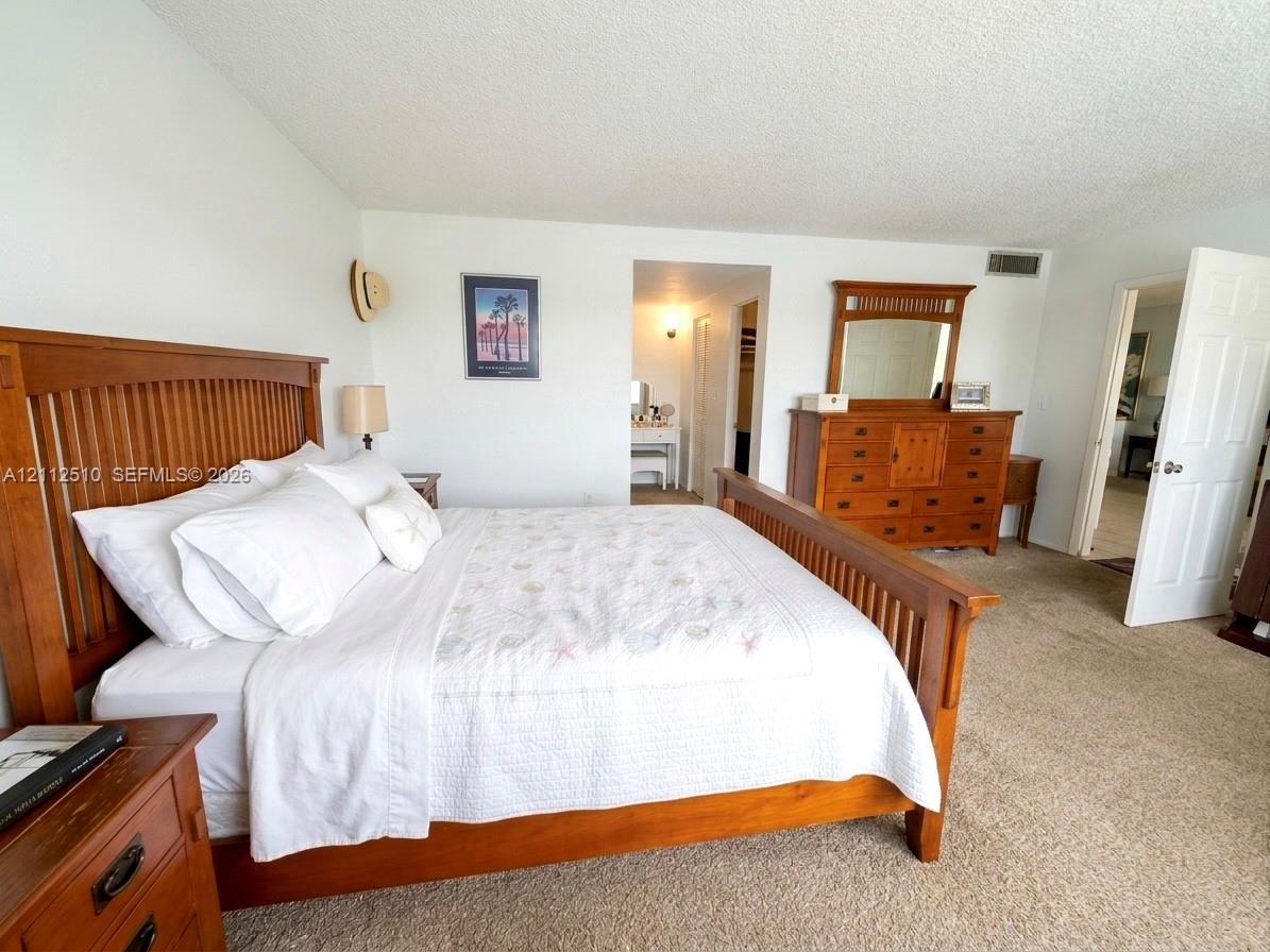 Bedroom featuring neutral wall-to-wall carpeting and a multi-panel door