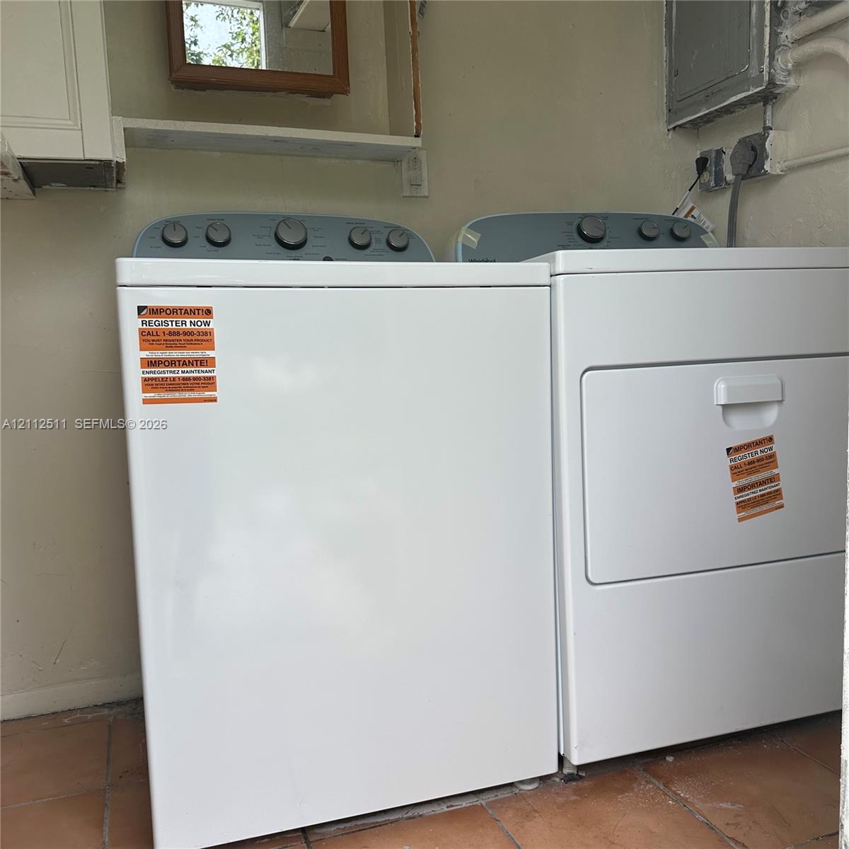 Laundry area featuring ceramic tile flooring, built-in cabinetry, and dedicated electrical hookups