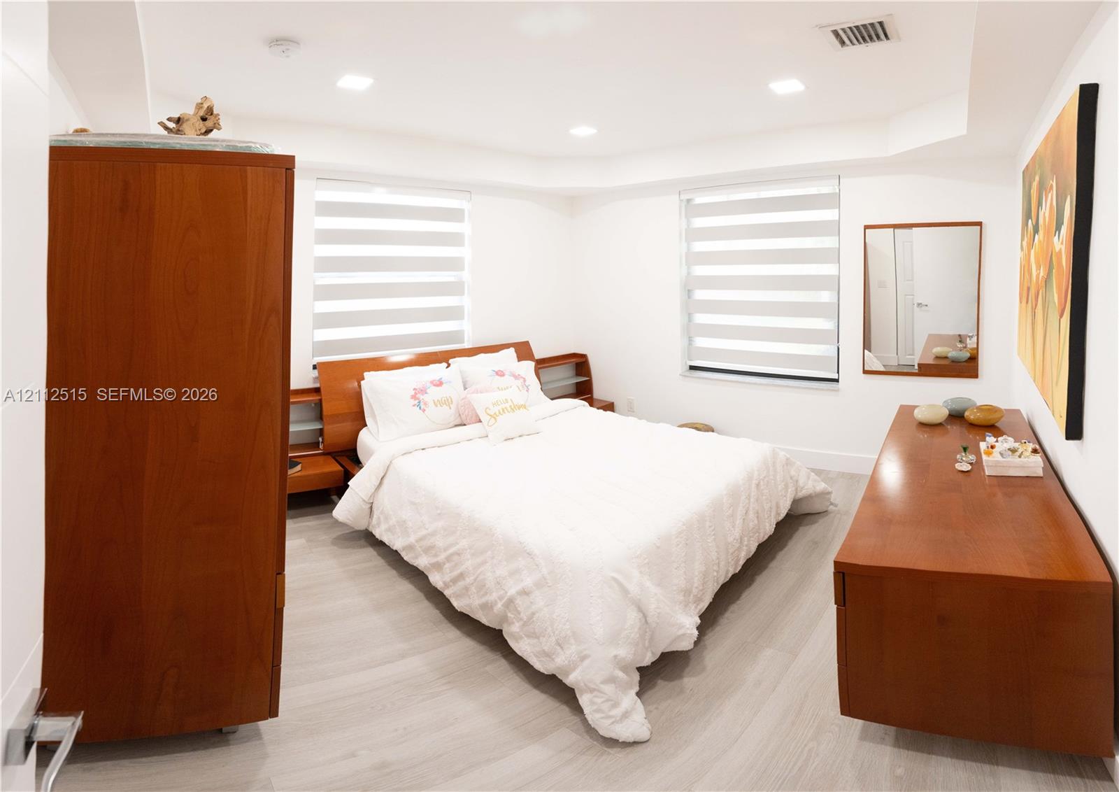 Neutral-toned wood-finish flooring, recessed ceiling lighting, and dual-layered window shades
