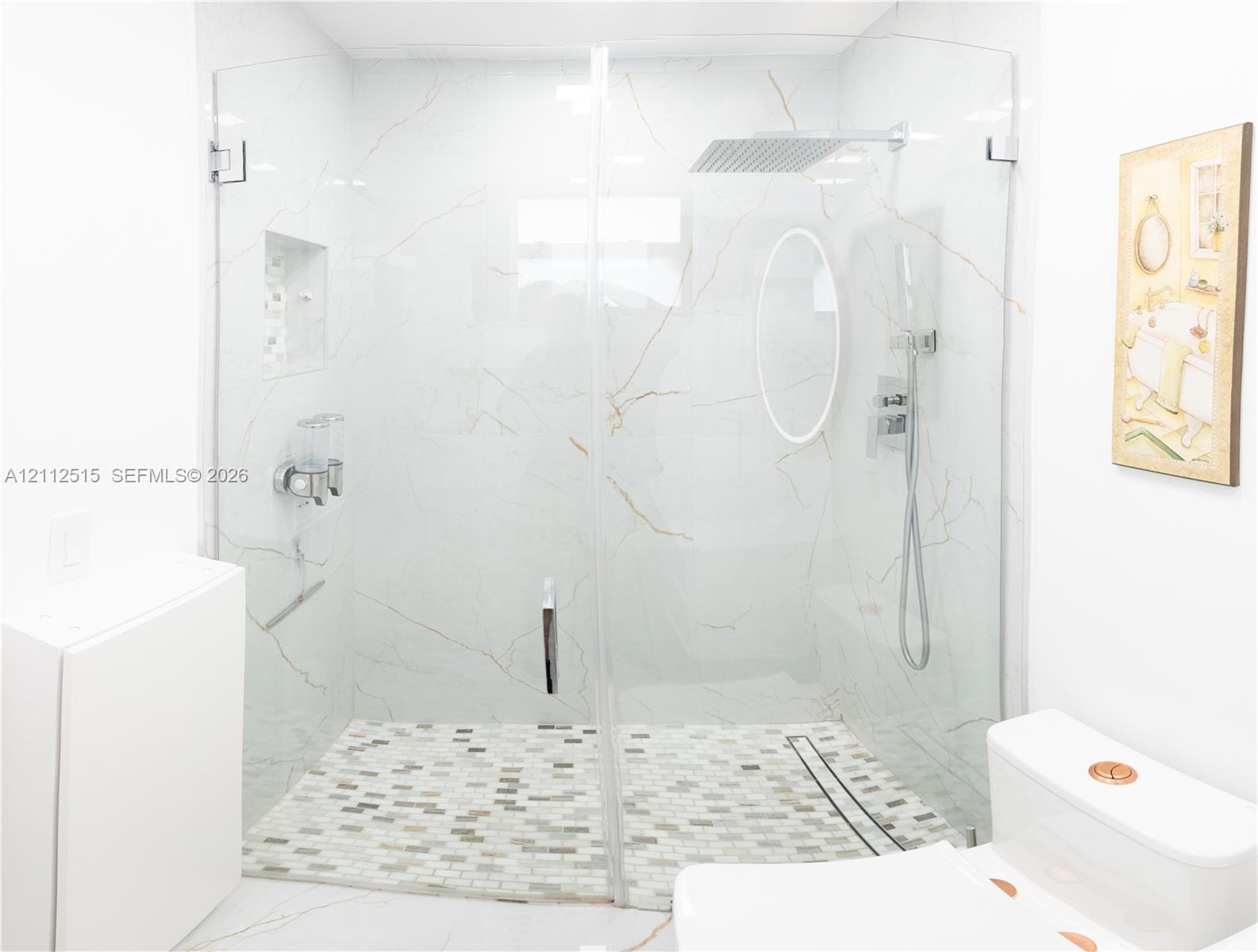 Walk-in shower featuring large-format wall tile with gold veining, a frameless glass enclosure, a mosaic-tiled floor, a rainfall showerhead, and a built-in recessed wall niche