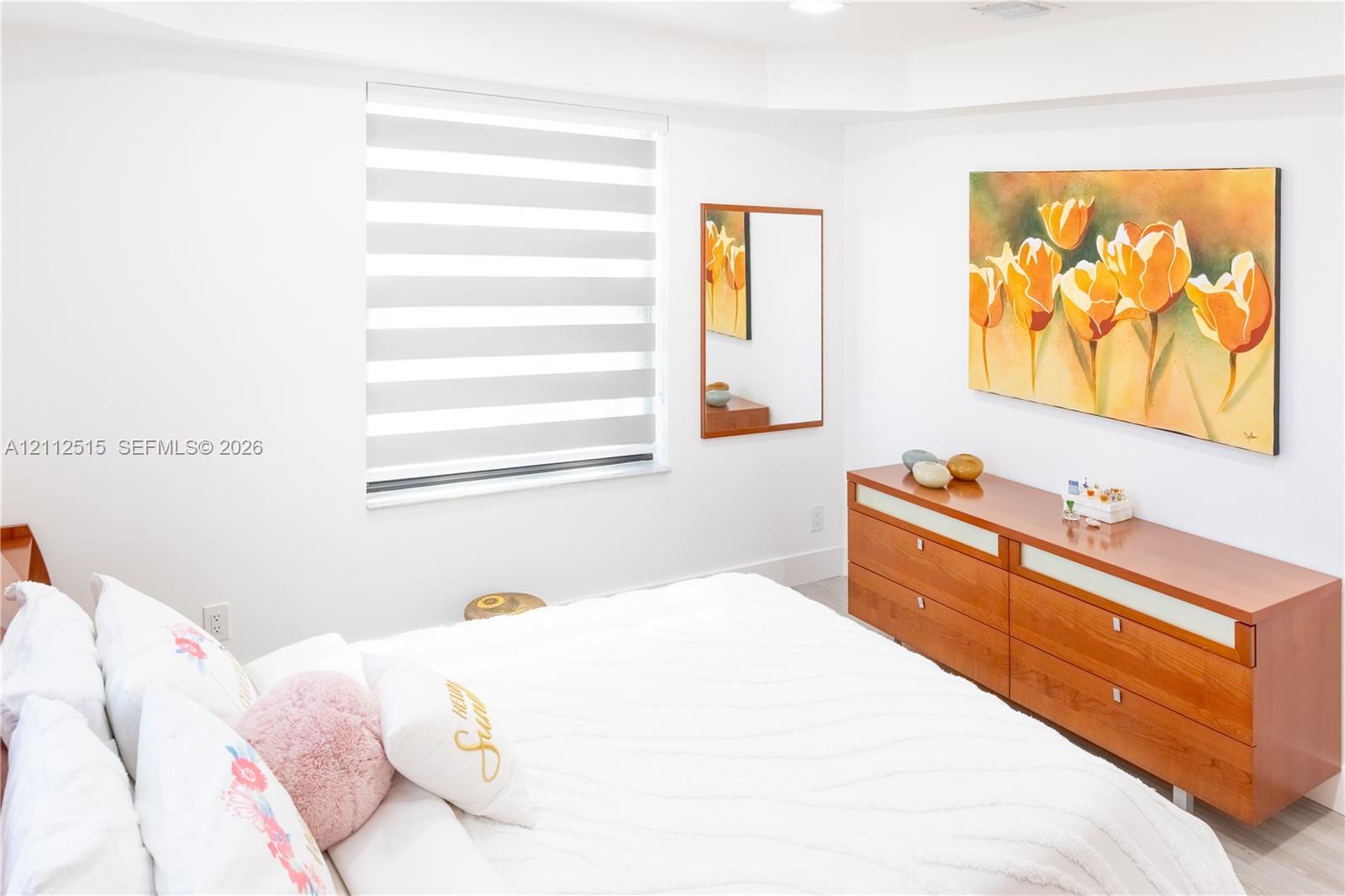 Bright room featuring recessed lighting and dual-layered cellular roller shades