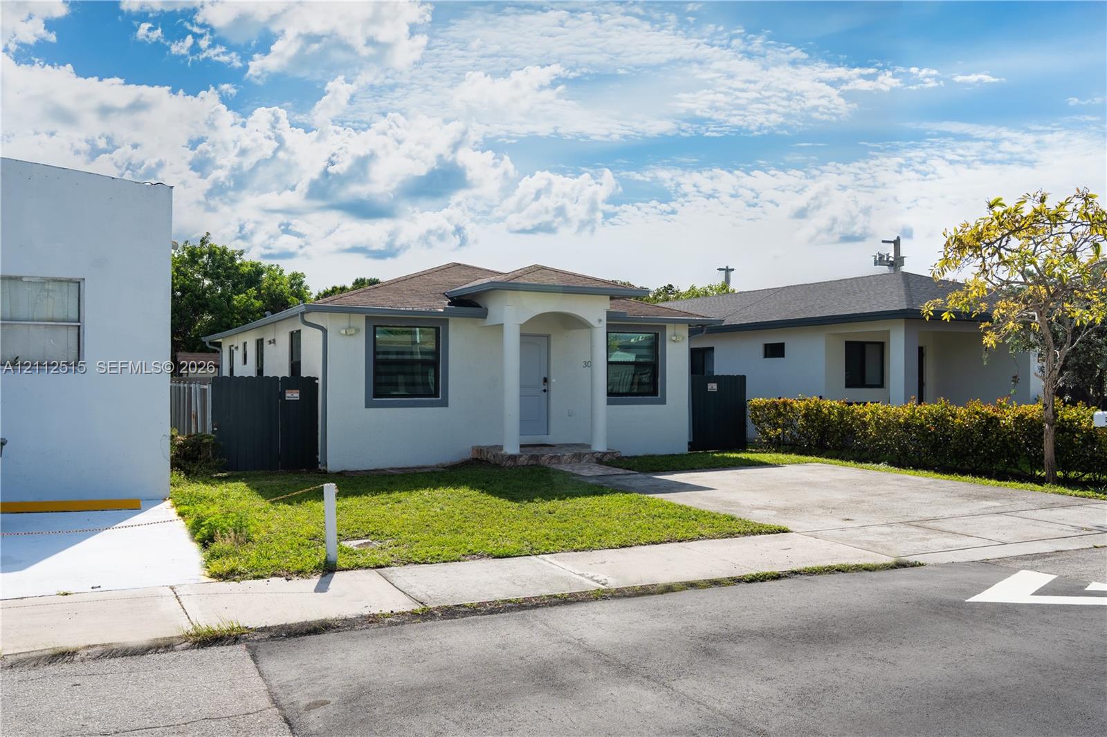 Single-story exterior featuring a hip roof, covered front entryway, concrete driveway, and solid-surface privacy fencing