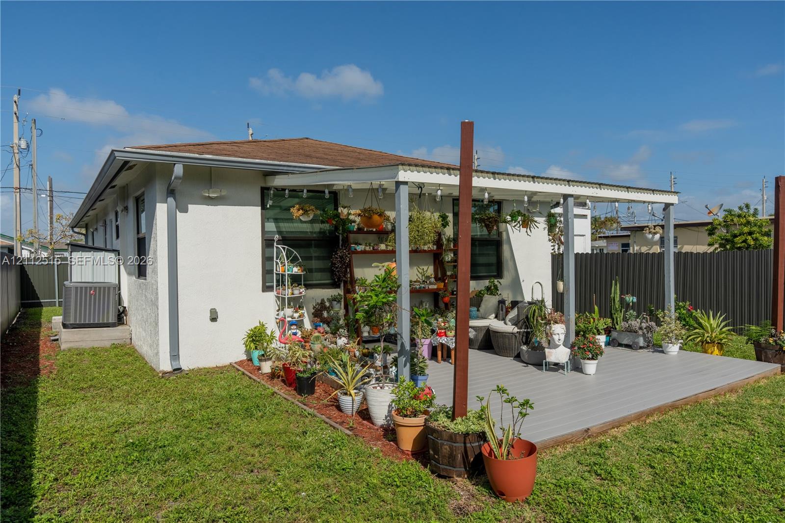 Exterior space featuring a covered deck, fenced perimeter, and dedicated ground-level HVAC unit