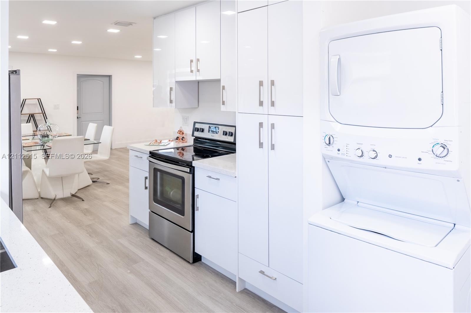 Kitchen featuring high-gloss white cabinetry, stone-finish countertops, stainless steel electric range, recessed ceiling lighting, and wood-finish flooring