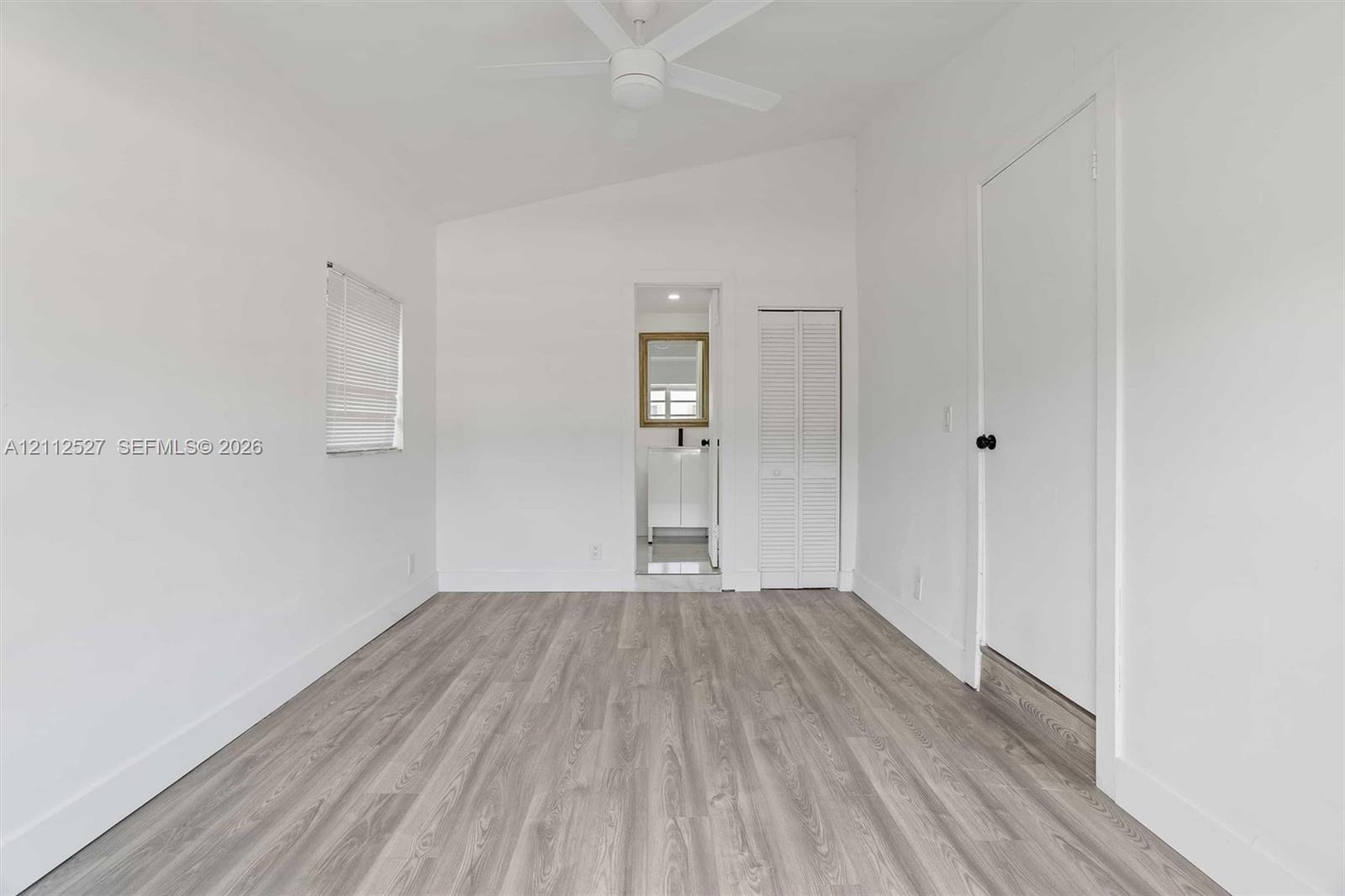 Vaulted ceilings, wood-finish flooring, ceiling fan, and louvered closet doors