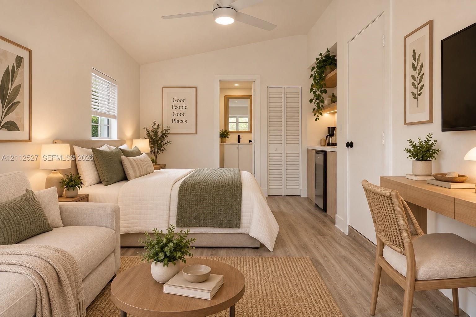 Vaulted ceilings with a central ceiling fan, wood-finish flooring, built-in kitchenette cabinetry, and louvered closet doors