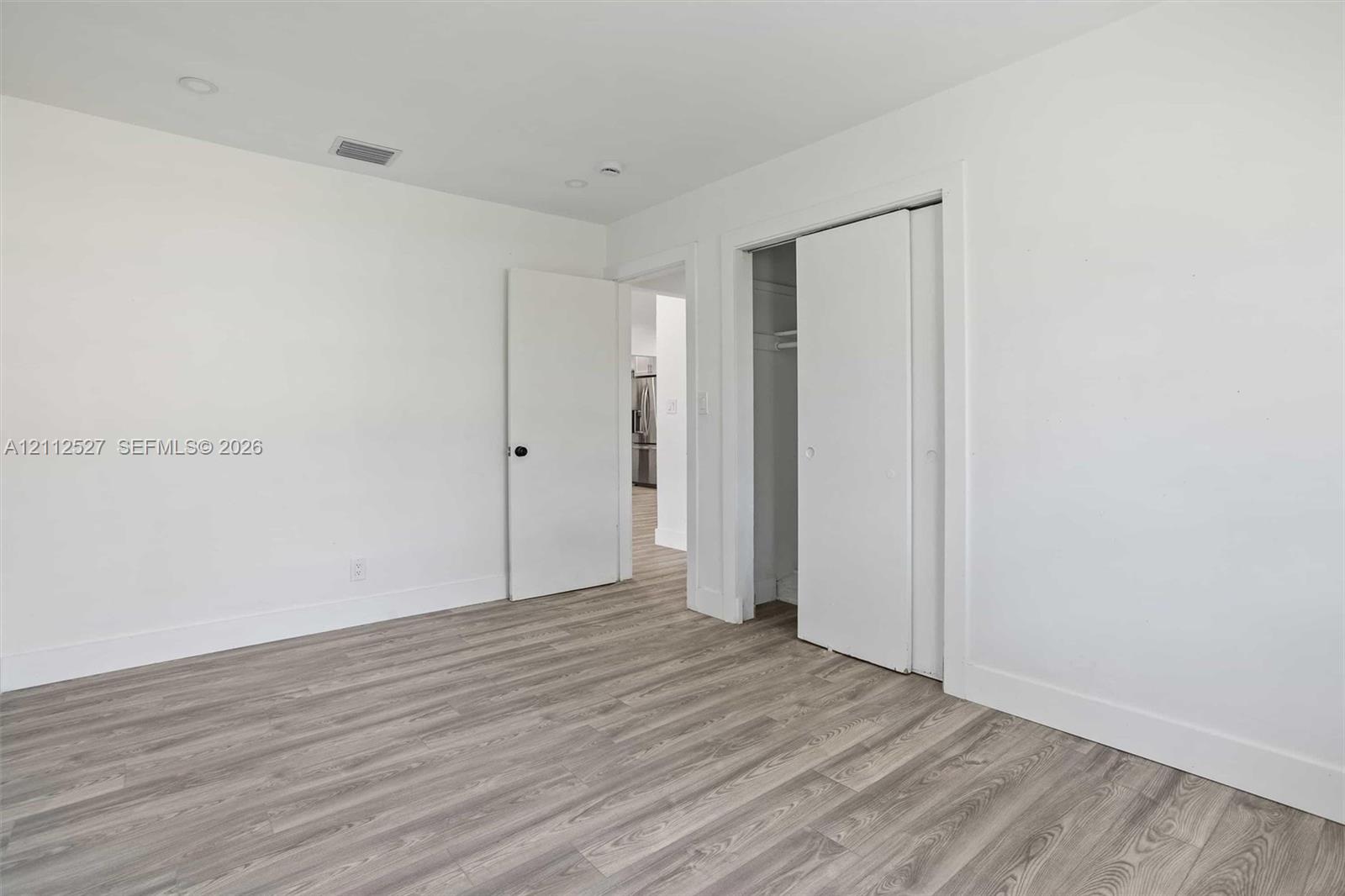 Interior space featuring wood-finish flooring, neutral walls, recessed lighting, and a closet with sliding doors