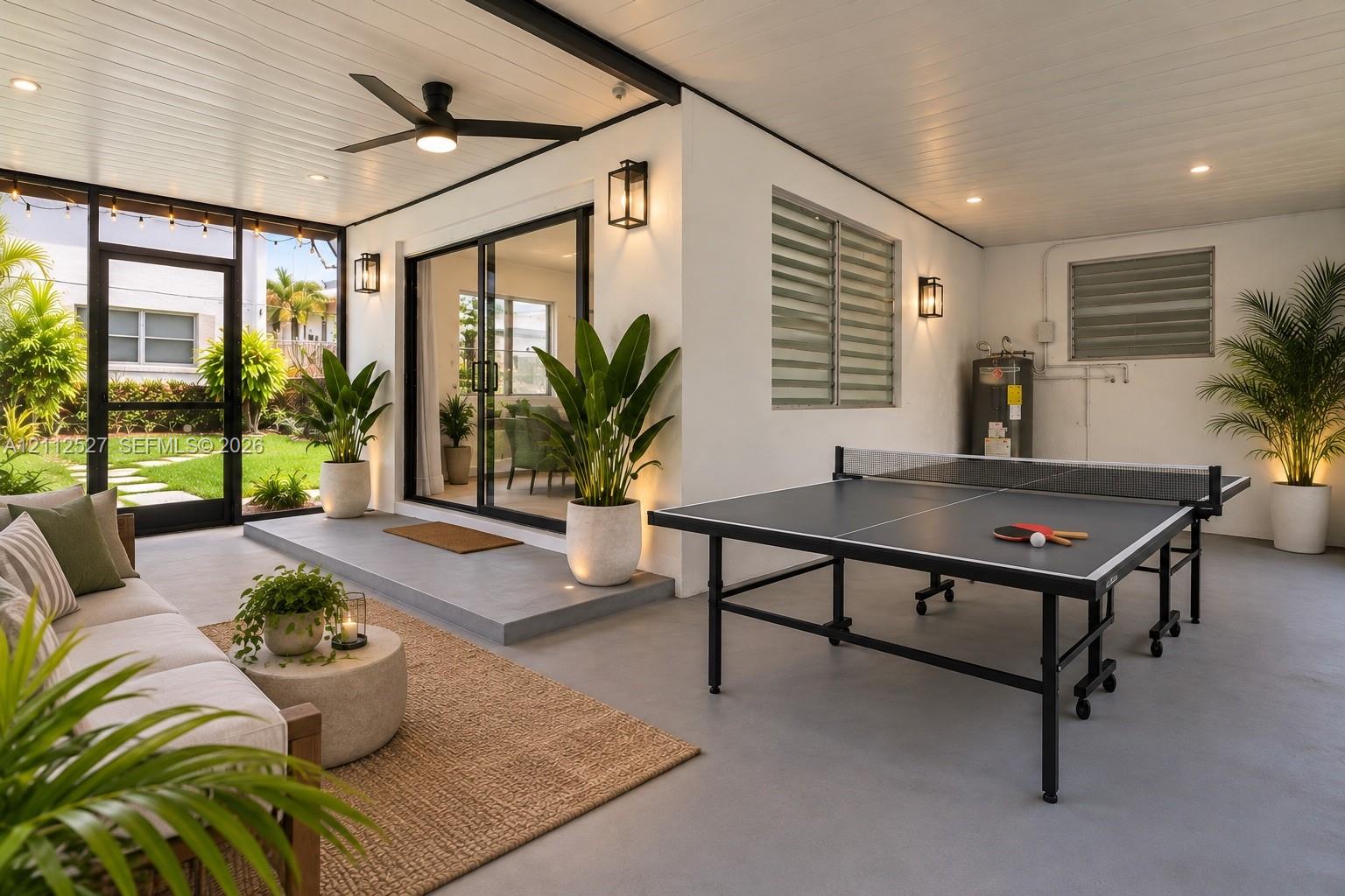 Covered outdoor living space featuring a concrete patio, recessed ceiling lighting, a ceiling fan, sliding glass doors, and louvered windows