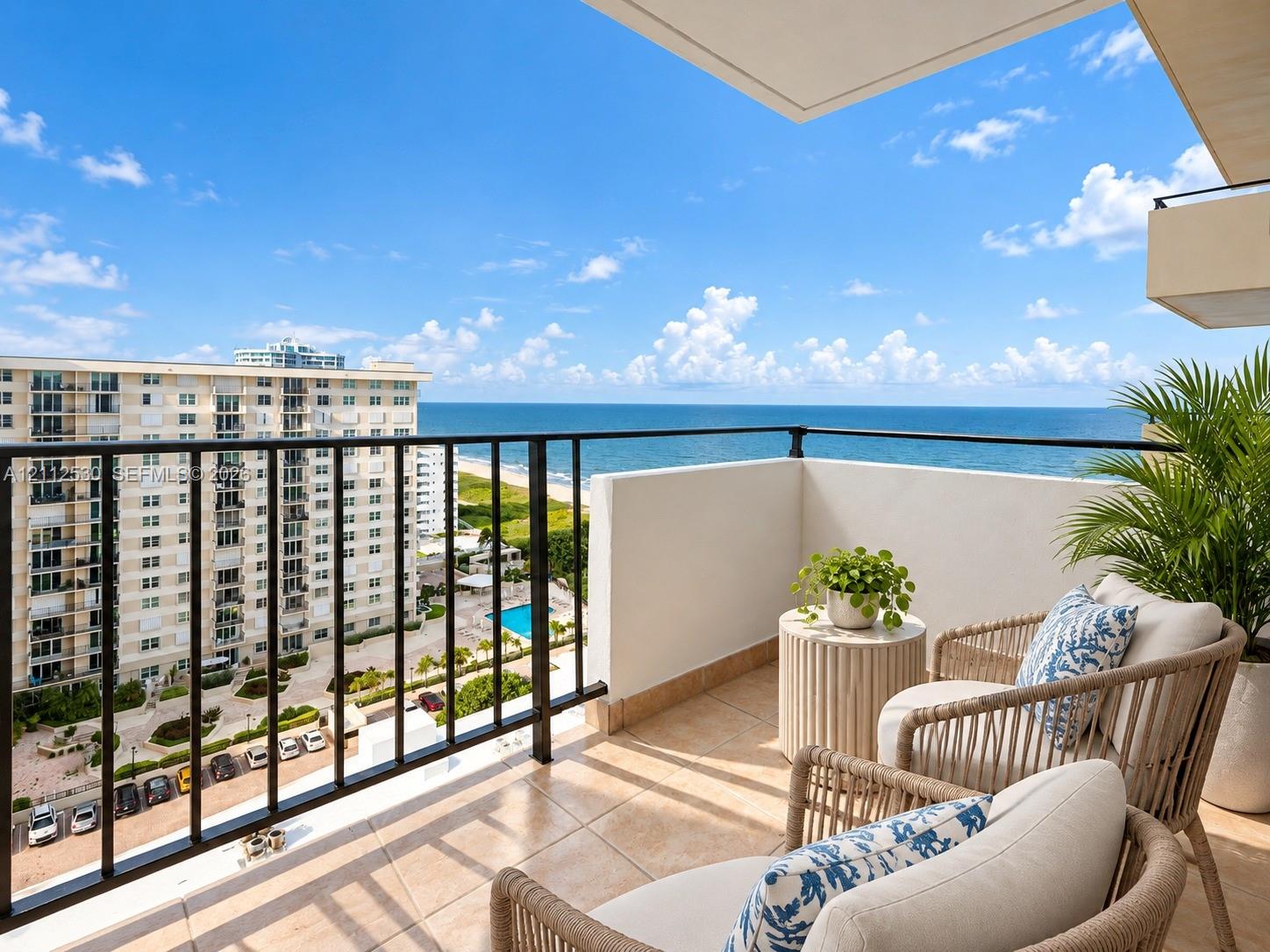 Private balcony featuring large-format tile flooring and metal railing overlooking the ocean and coastline