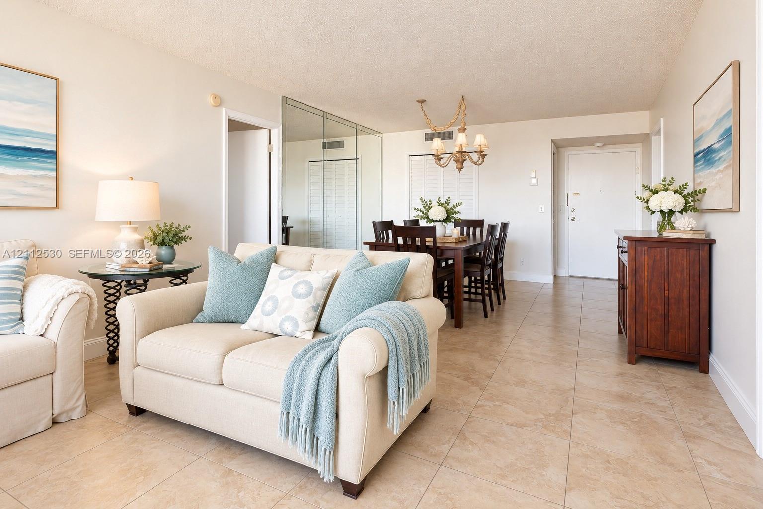 Neutral-tone tile flooring, mirrored sliding closet doors, and decorative multi-arm chandelier lighting