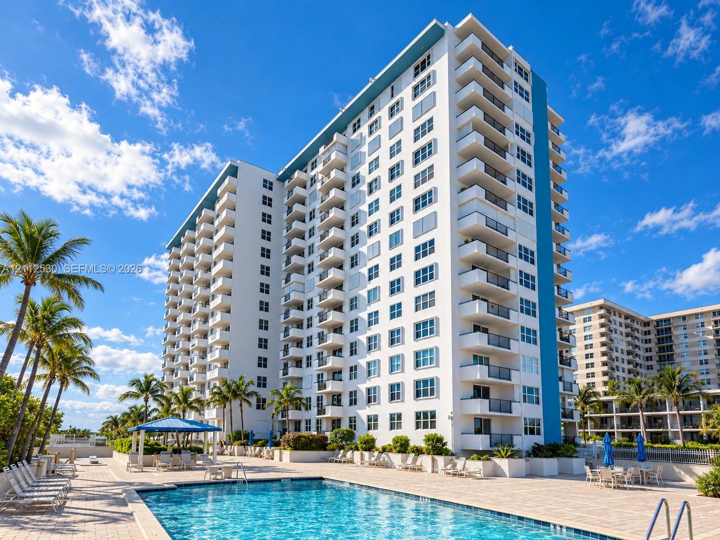 High-rise building featuring private balconies, swimming pool, paved pool deck, and integrated landscaping with mature palm trees