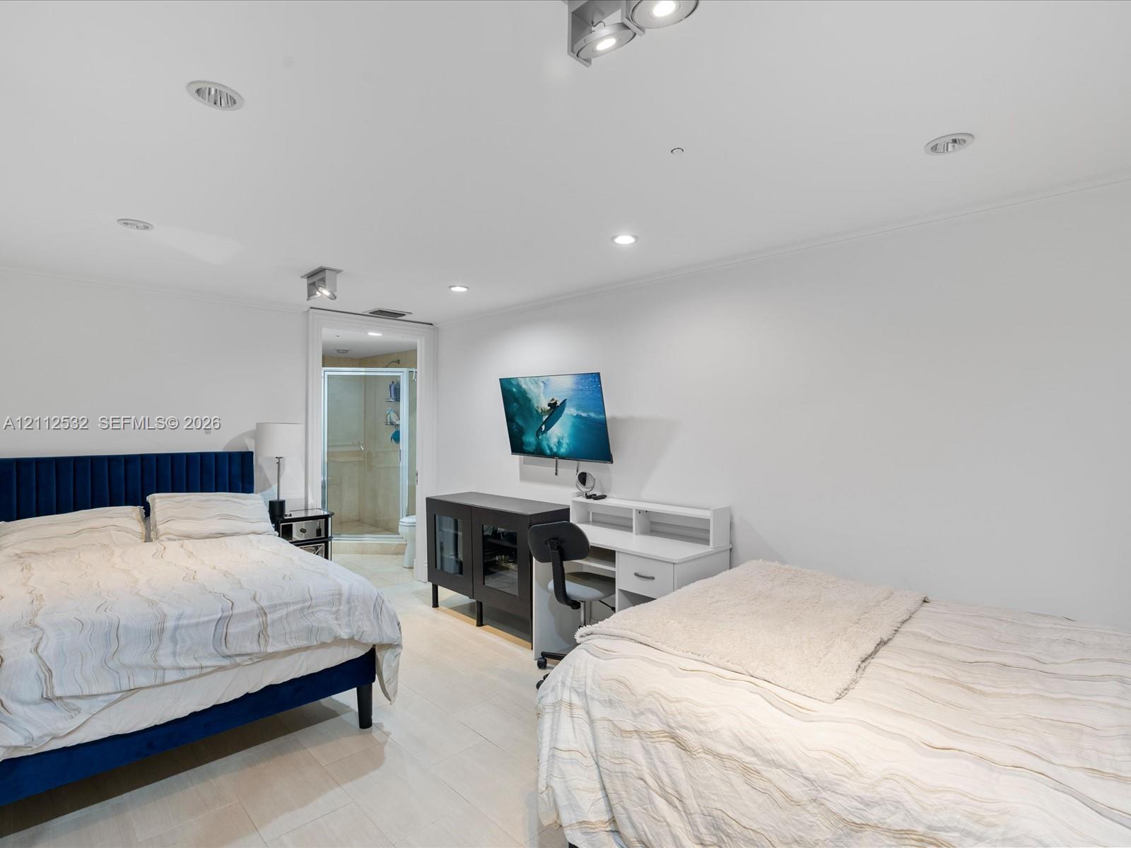 Recessed ceiling lighting, light-toned flooring, and wall-mounted television bracket