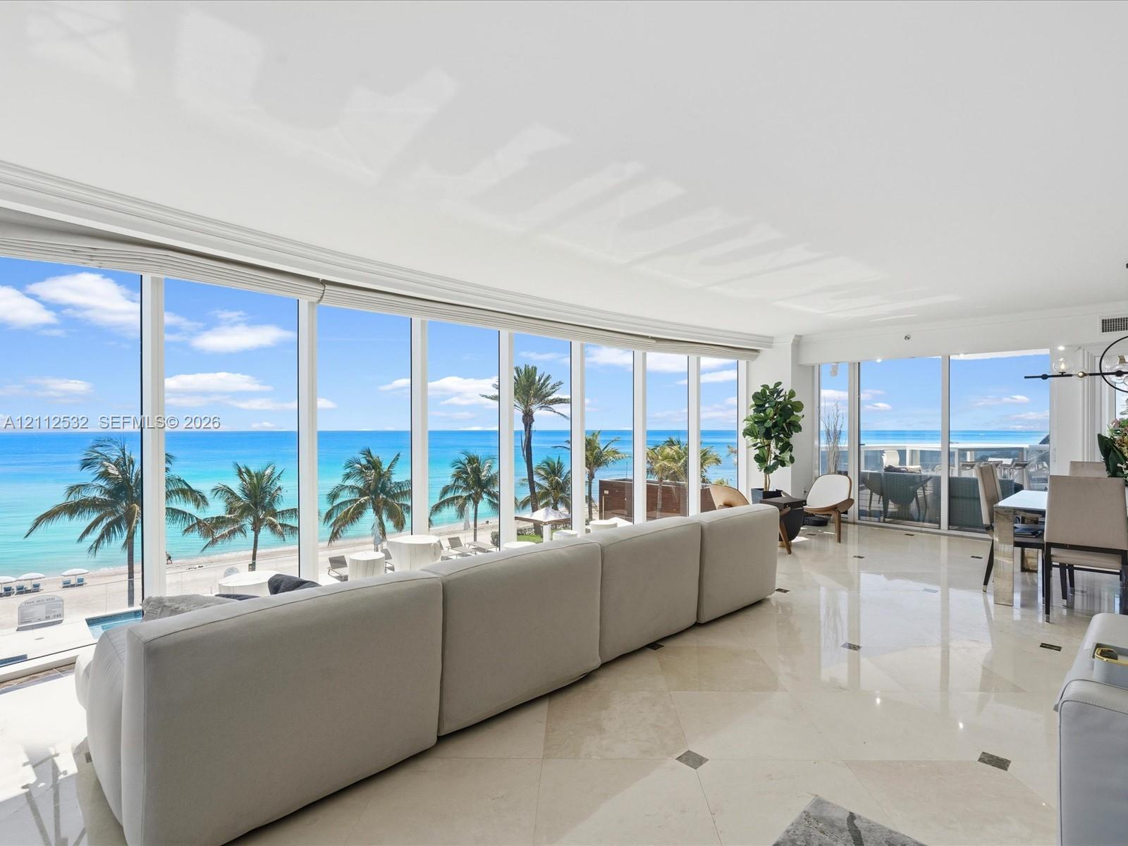 Floor-to-ceiling windows, polished stone tile flooring with decorative inlay, and coastal scenery Floor-to-ceiling windows, polished stone tile flooring with decorative inlay, and coastal scenery