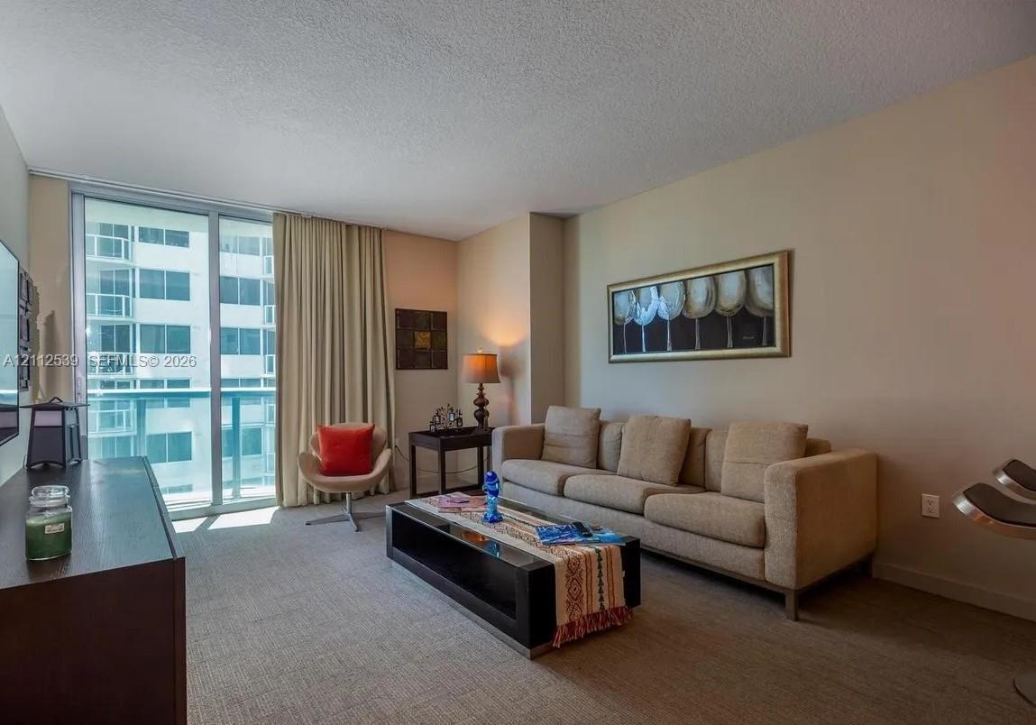 Floor-to-ceiling sliding glass door providing natural light and access to the exterior balcony