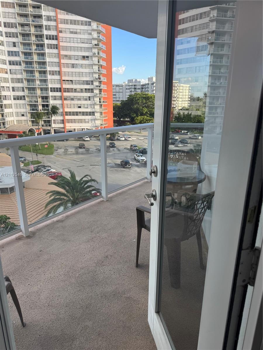 Private balcony featuring a concrete floor and a glass panel railing with a white frame