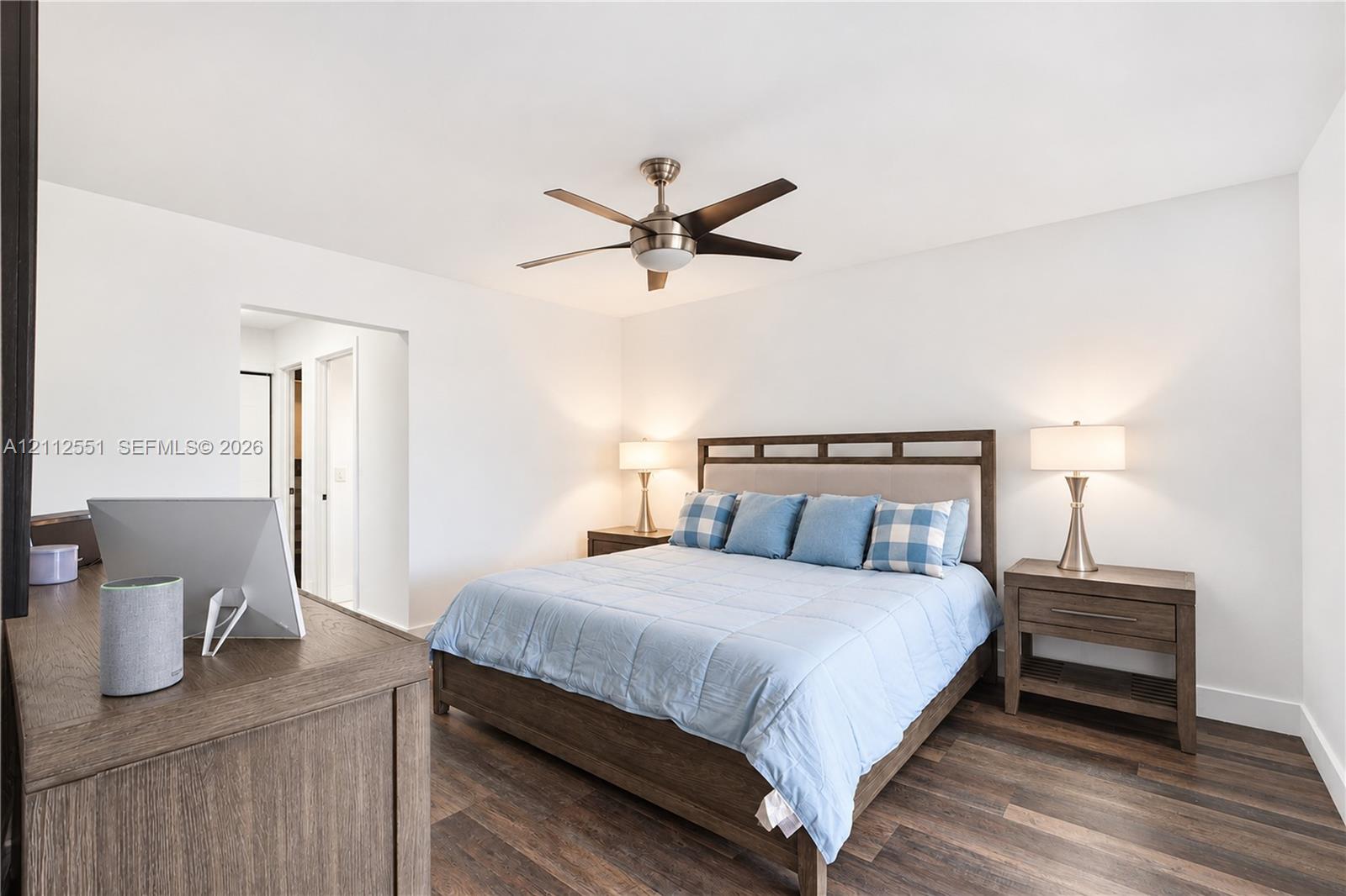Neutral-toned interior featuring wood-finish flooring and a ceiling-mounted fan with integrated lighting