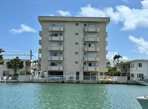 Multi-story residential building featuring private balconies, concrete construction, and direct bulkhead access to the waterway