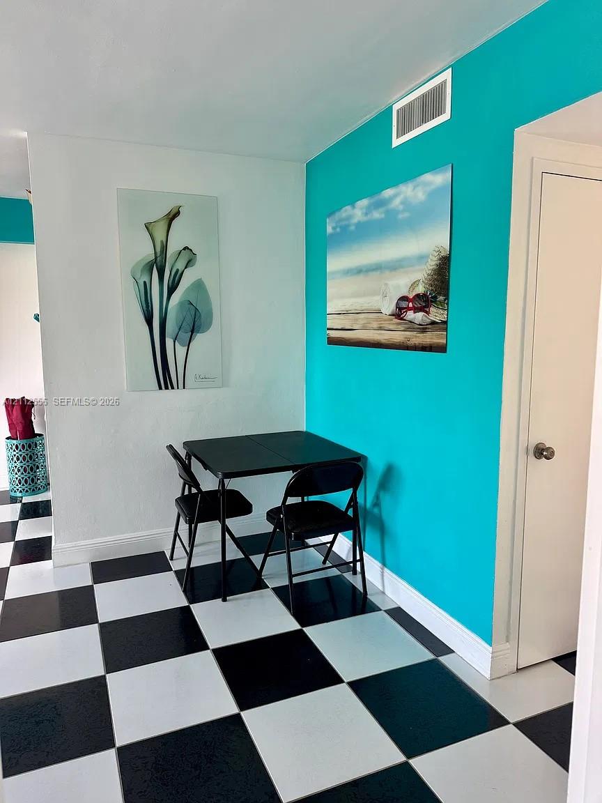 High-contrast black and white checkerboard flooring complemented by an accent wall