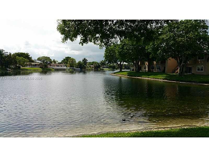 Waterfront property featuring expansive lake frontage, mature shade trees, and manicured green space