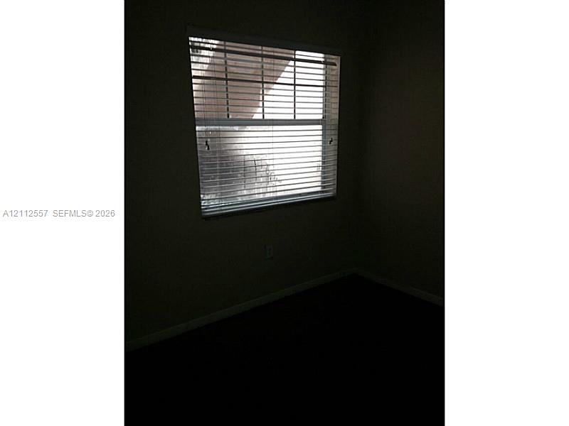 Single-hung window featuring horizontal blinds and neutral-toned wall paint