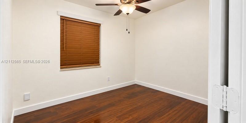 Room featuring wood-finish flooring, a ceiling fan with integrated lighting, and window blinds
