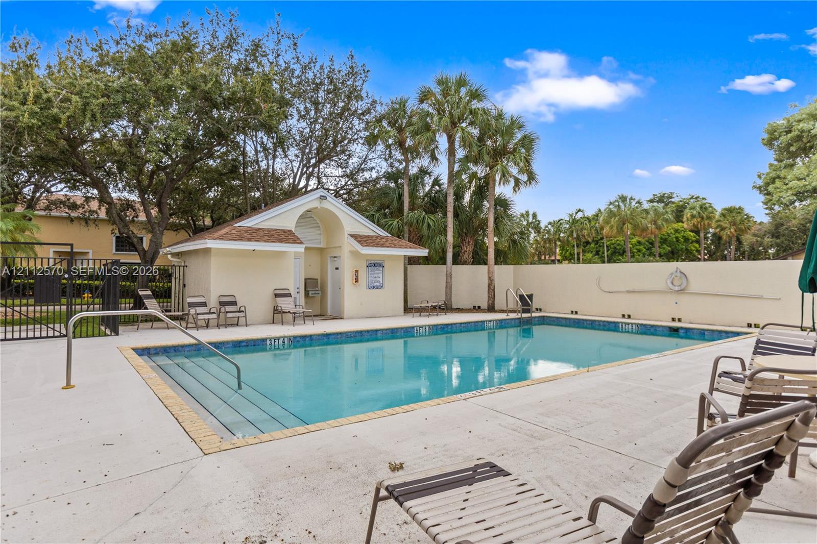 Swimming pool with integrated stair entry, light-toned concrete decking, and an enclosed pavilion structure