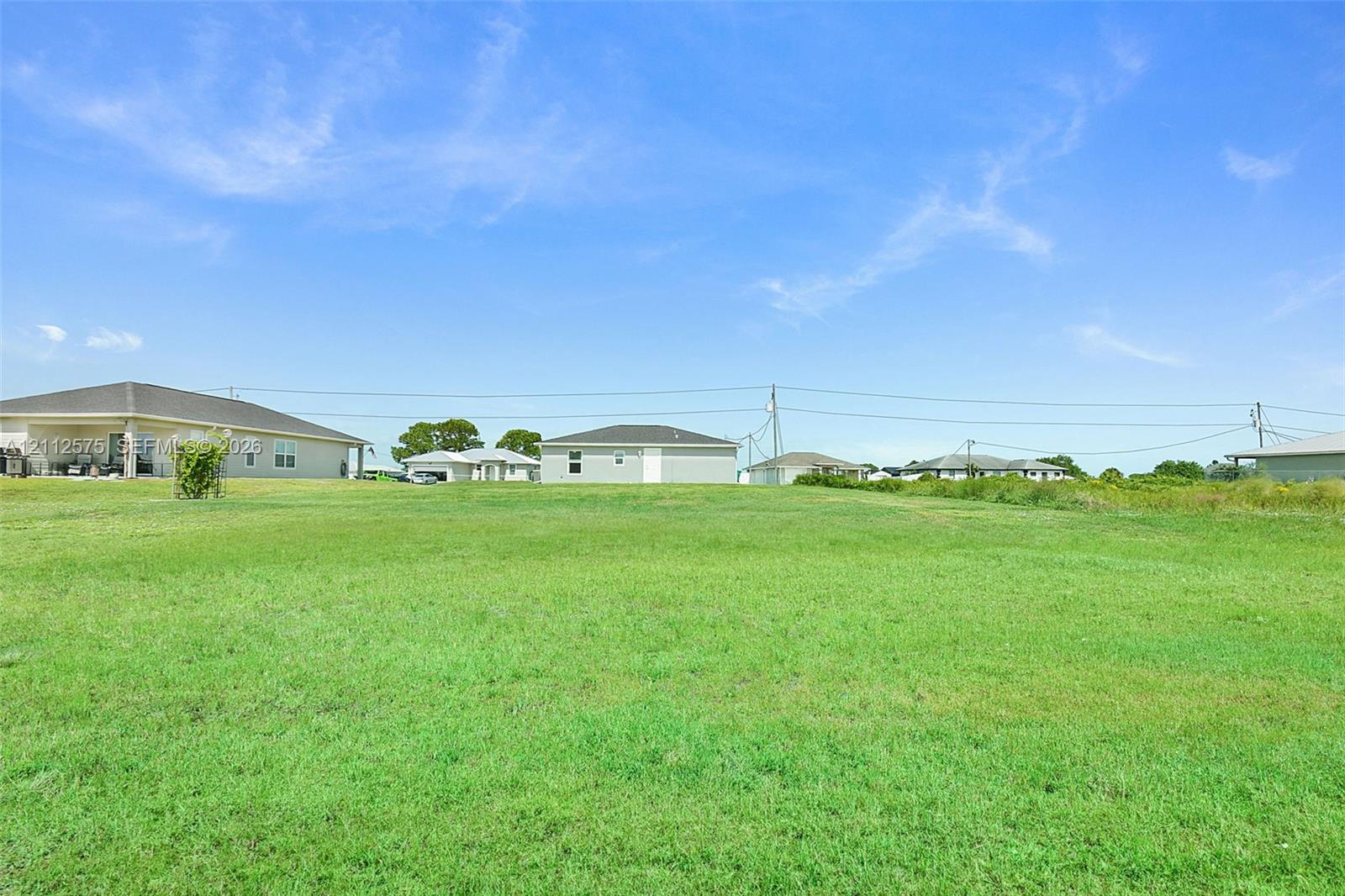 Expansive open lot featuring level grass terrain and clear horizon lines