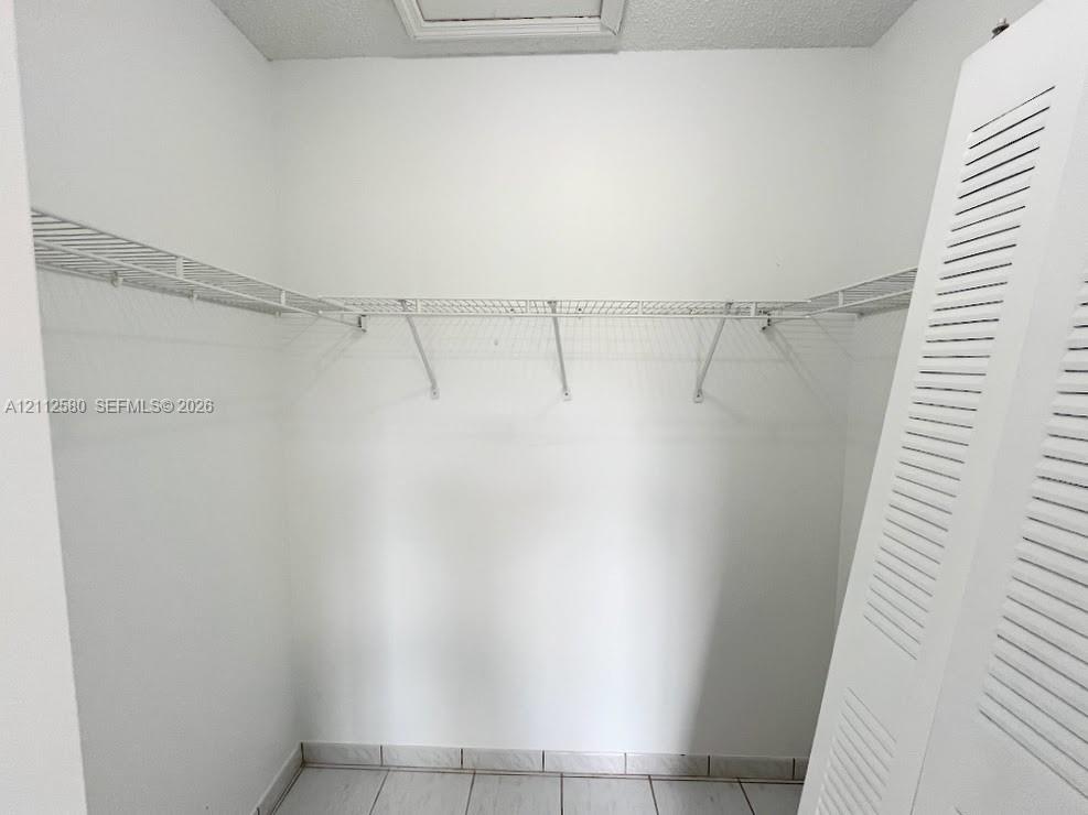 Storage area featuring wire shelving and white louvered doors