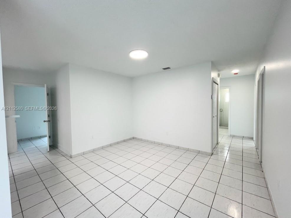 Interior space featuring white walls and white ceramic floor tiling Interior space featuring white walls and white ceramic floor tiling