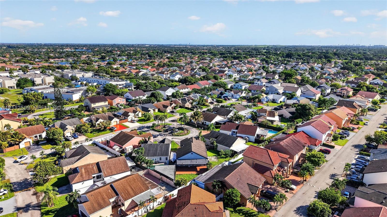 Aerial perspective of a suburban neighborhood featuring paved streets, established residential lots, mature landscaping, and diverse roofline profiles
