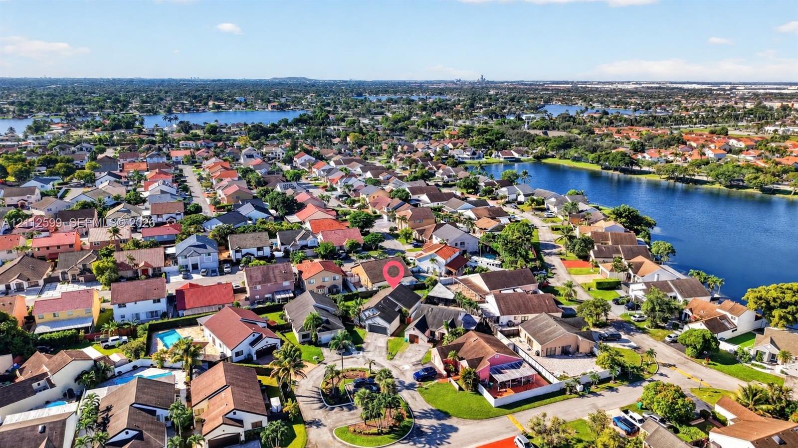 Aerial perspective featuring a residential lot situated within a waterfront community, including access to local canal systems and established mature landscaping