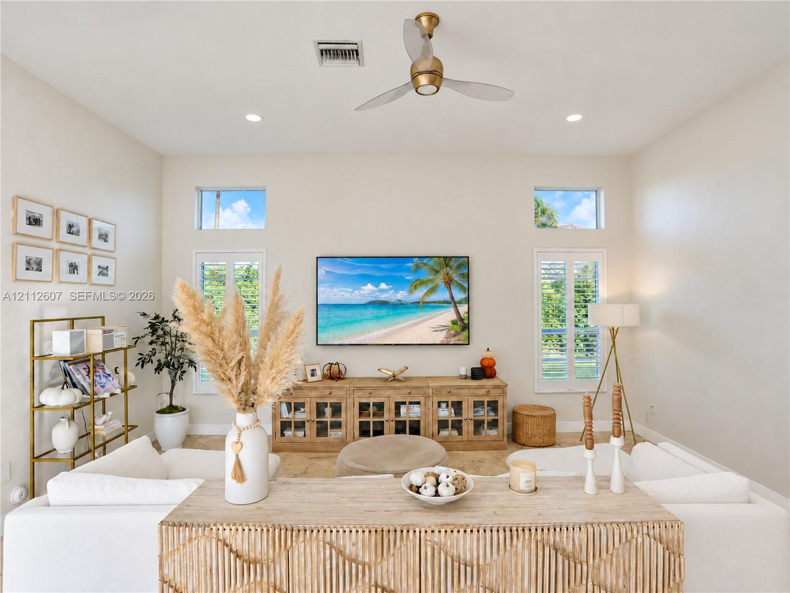 High ceilings featuring a central ceiling fan, neutral wall finishes, recessed lighting, double-hung windows with white shutters, and clerestory windows