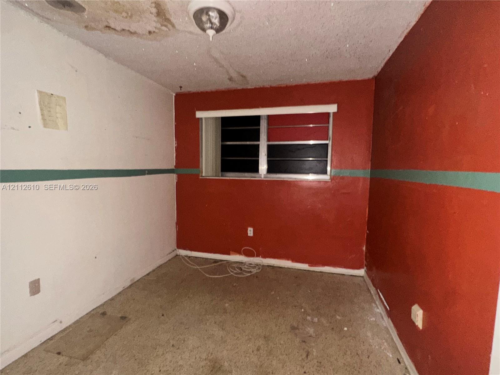 Room featuring painted walls, a horizontal sliding window, and a ceiling-mounted light fixture
