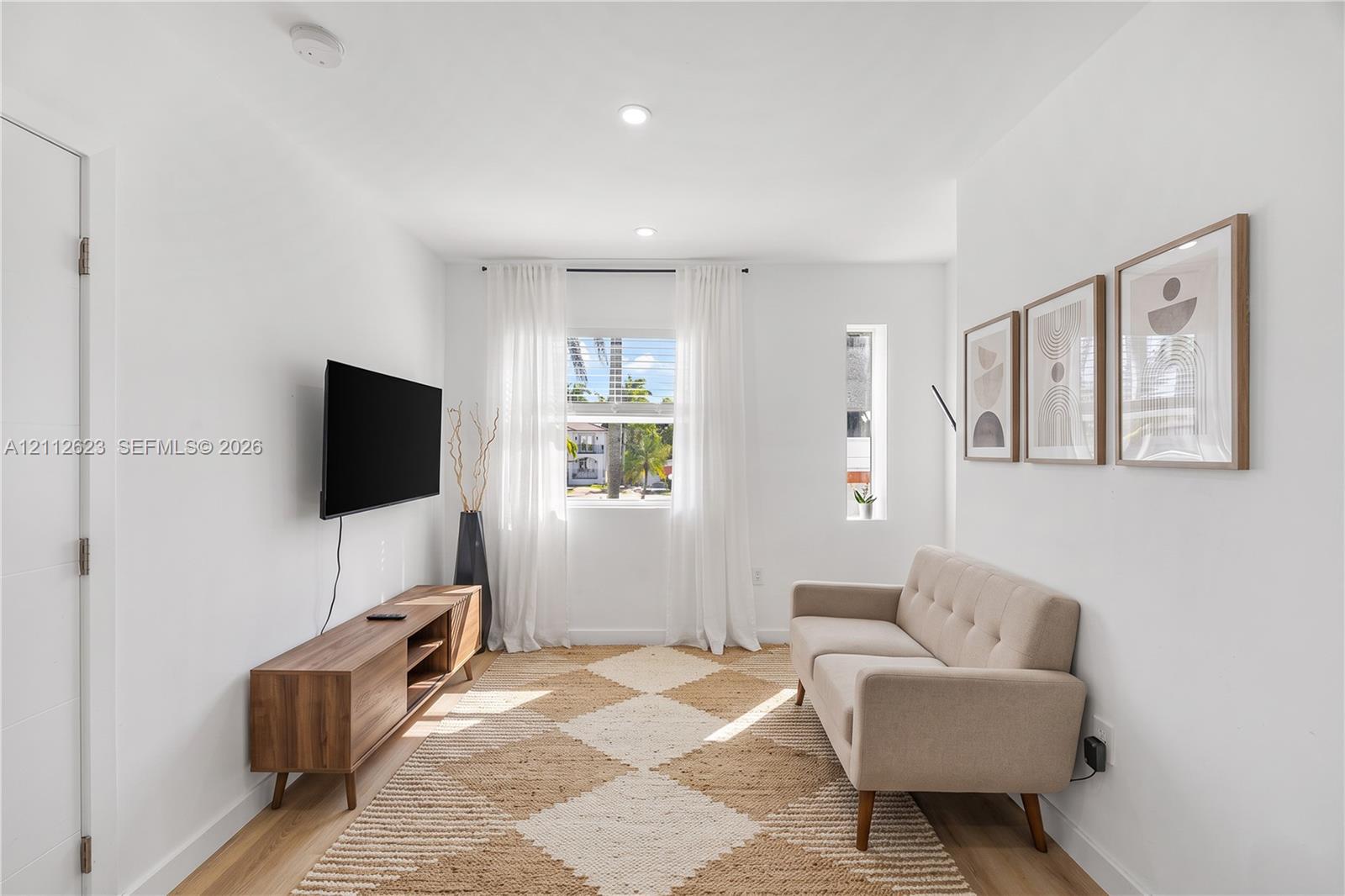 Interior space featuring wood-finish flooring, recessed lighting, and dual-pane window configuration including a vertical fixed-pane window