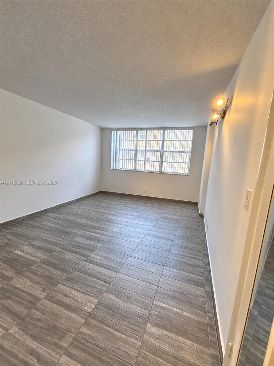 Wood-finish tile flooring, large multi-pane window with integrated vertical blinds, and dual-bulb wall-mounted lighting fixture