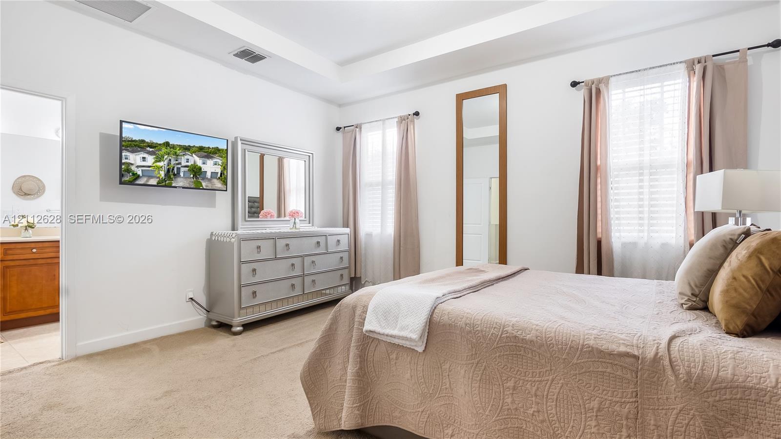 This refined primary bedroom blends comfort and sophistication, offering ample space to unwind along with a spacious walk-in closet and a beautifully appointed oversized ensuite bathroom designed for resort-style living.