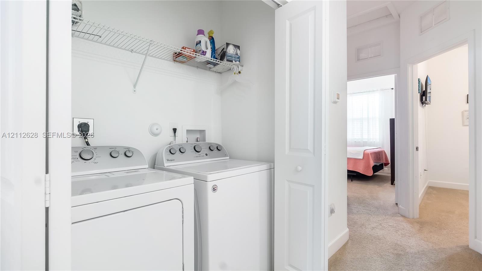 A convenient upstairs laundry closet with full-size machines and open shelvingdesigned to make everyday routines simple, organized, and efficient.