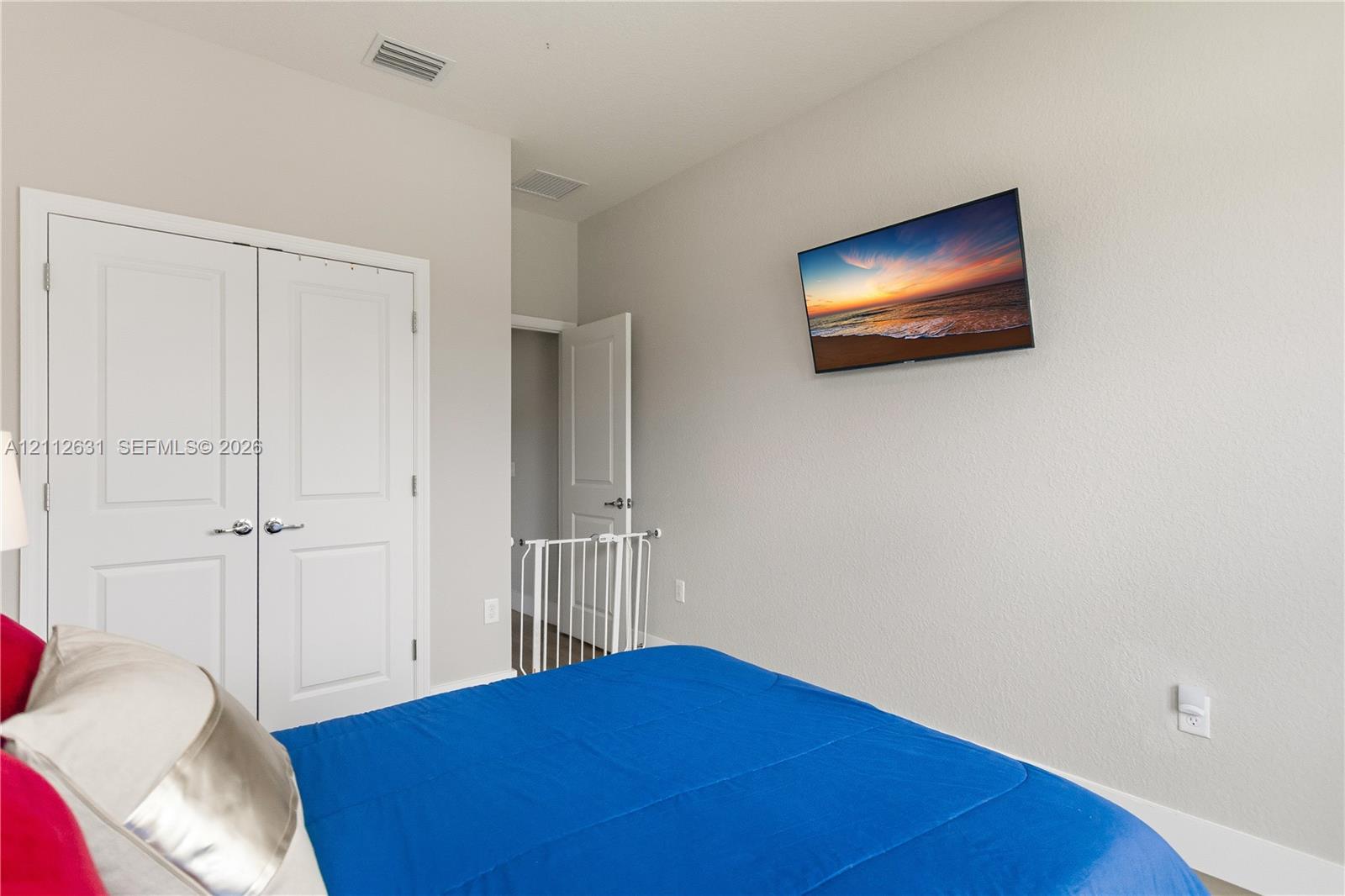 Neutral-toned room with double-panel doors and a wall-mounted display
