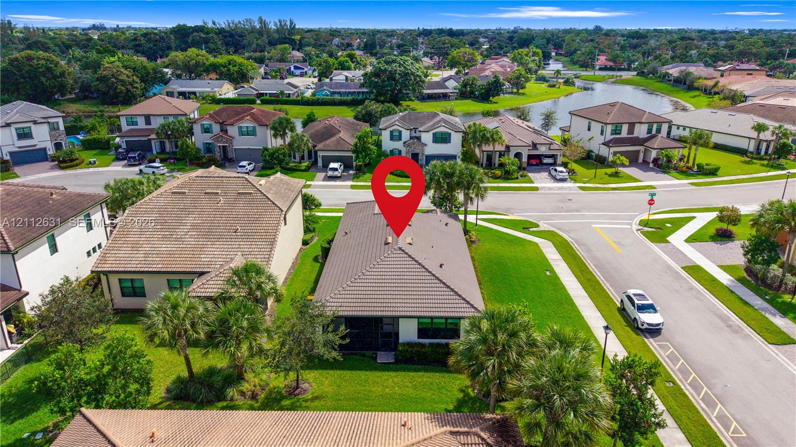 Single-story residence featuring a tile roof, light-toned exterior finish, and a corner lot location with curated landscaping