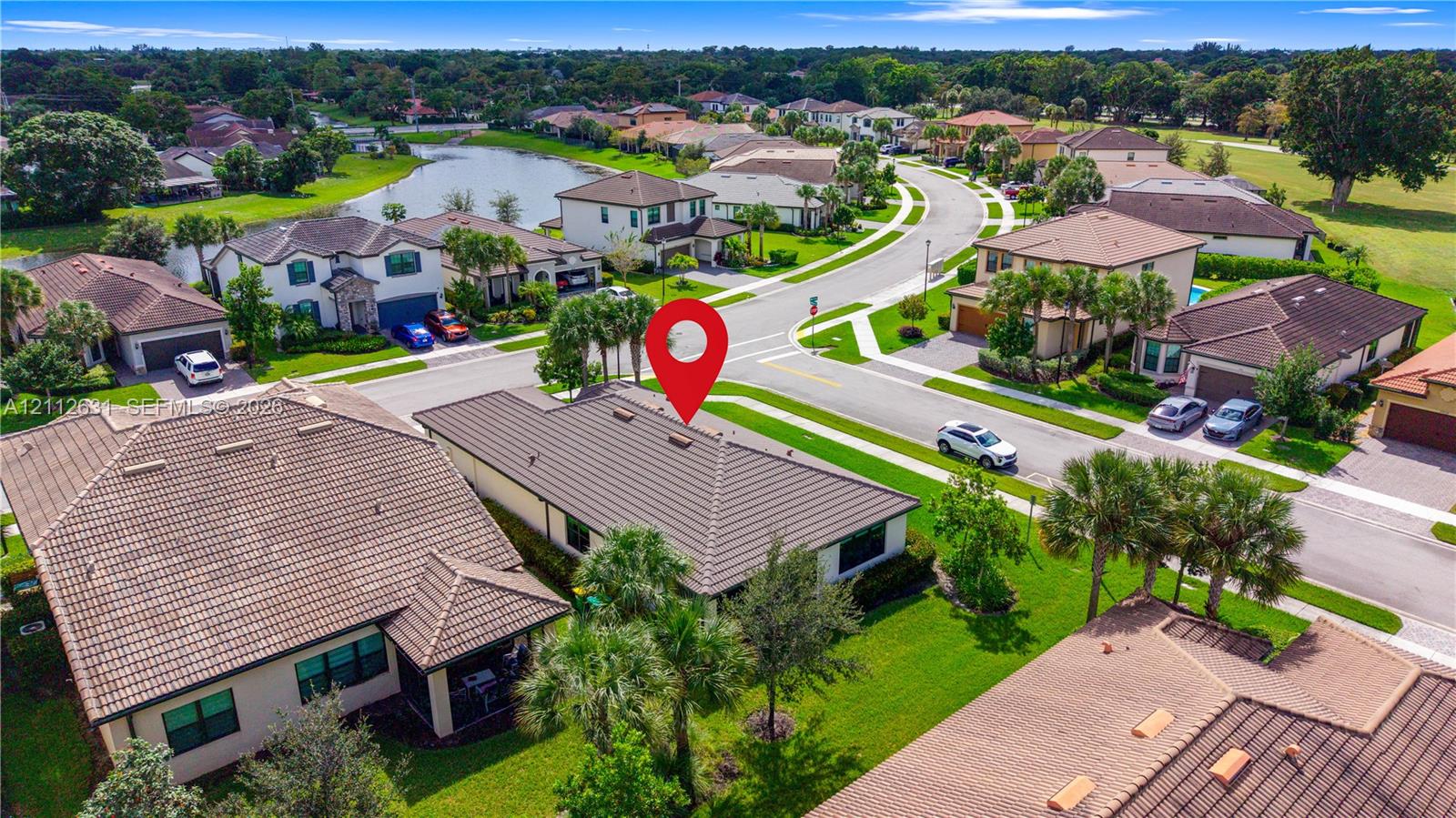 Aerial perspective of a residential property featuring a hip roof, stucco exterior, integrated garage, and manicured landscaping