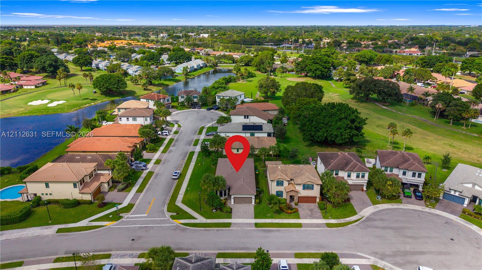 Aerial perspective of a single-family residence featuring a paved driveway, attached multi-car garage, and a hip roof, situated on a residential cul-de-sac