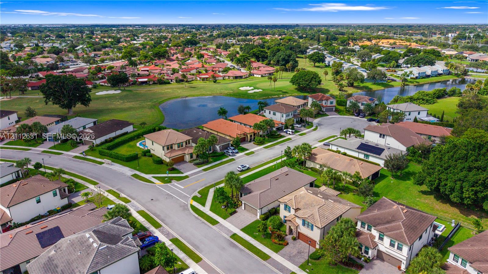 Aerial perspective of a suburban neighborhood featuring residential lots with cul-de-sac streets, integrated water features, and manicured landscaping