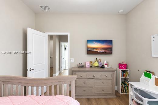 Neutral wall tones, wood-finish flooring, and a six-panel interior door