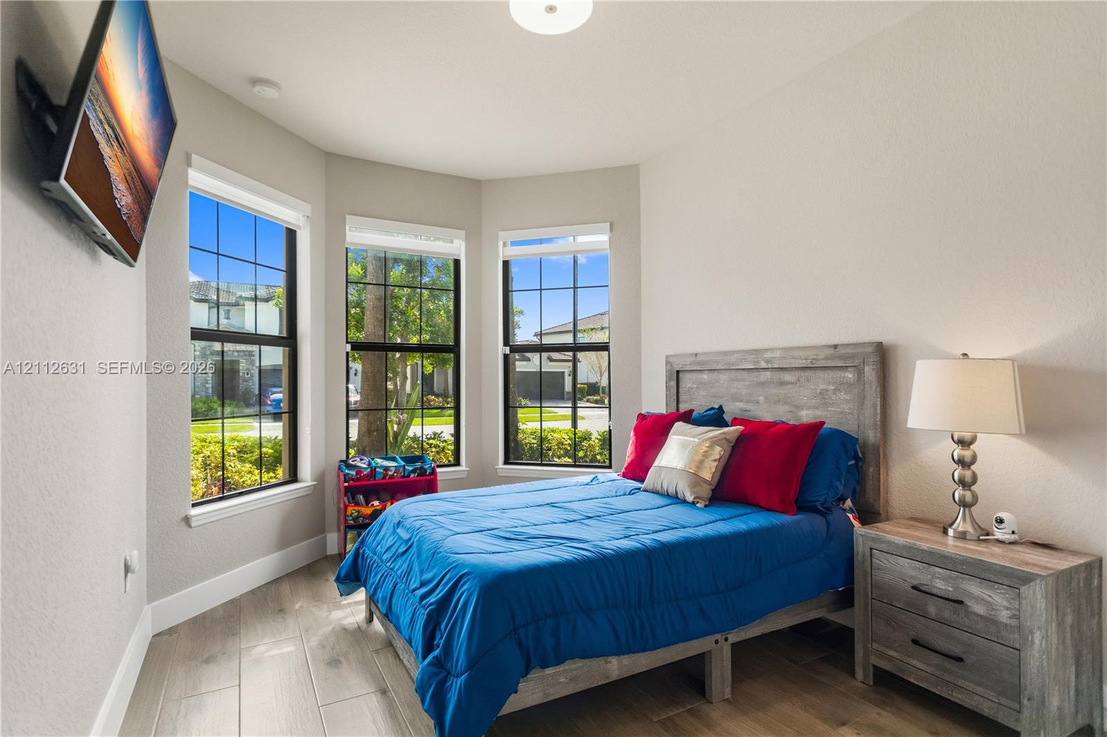Bay window featuring grid-pattern windows, wood-finish flooring, and recessed ceiling lighting