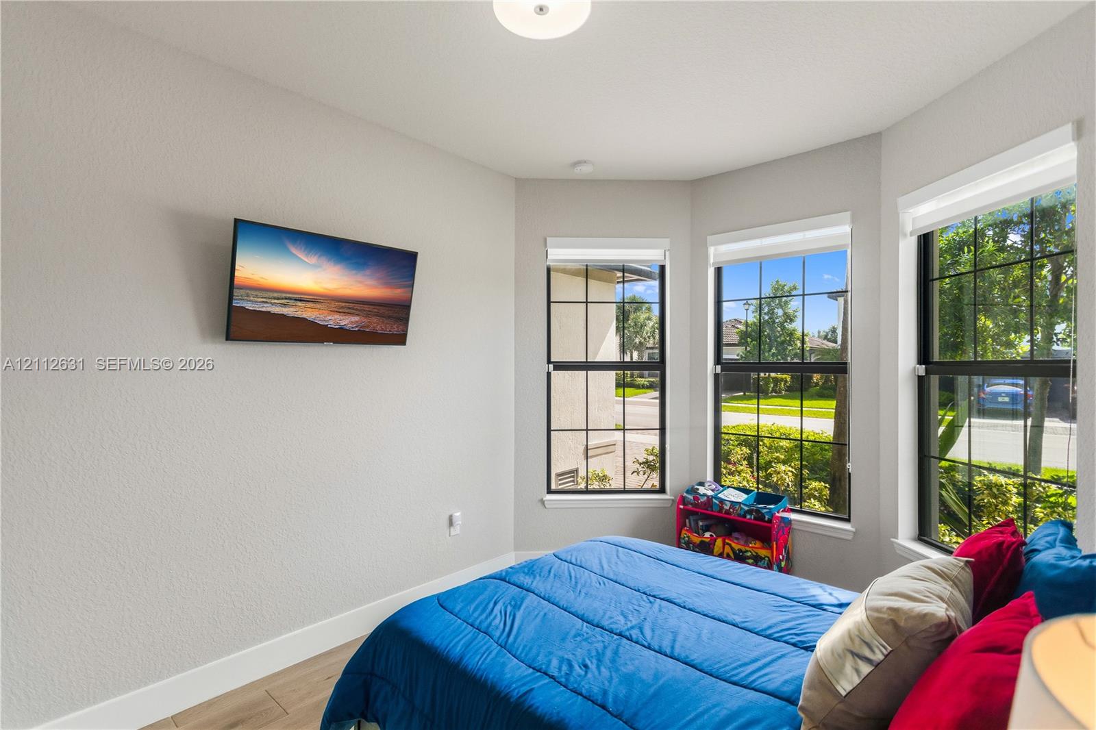Bay window featuring large dual-pane windows with dark frames, wood-finish flooring, and recessed ceiling lighting