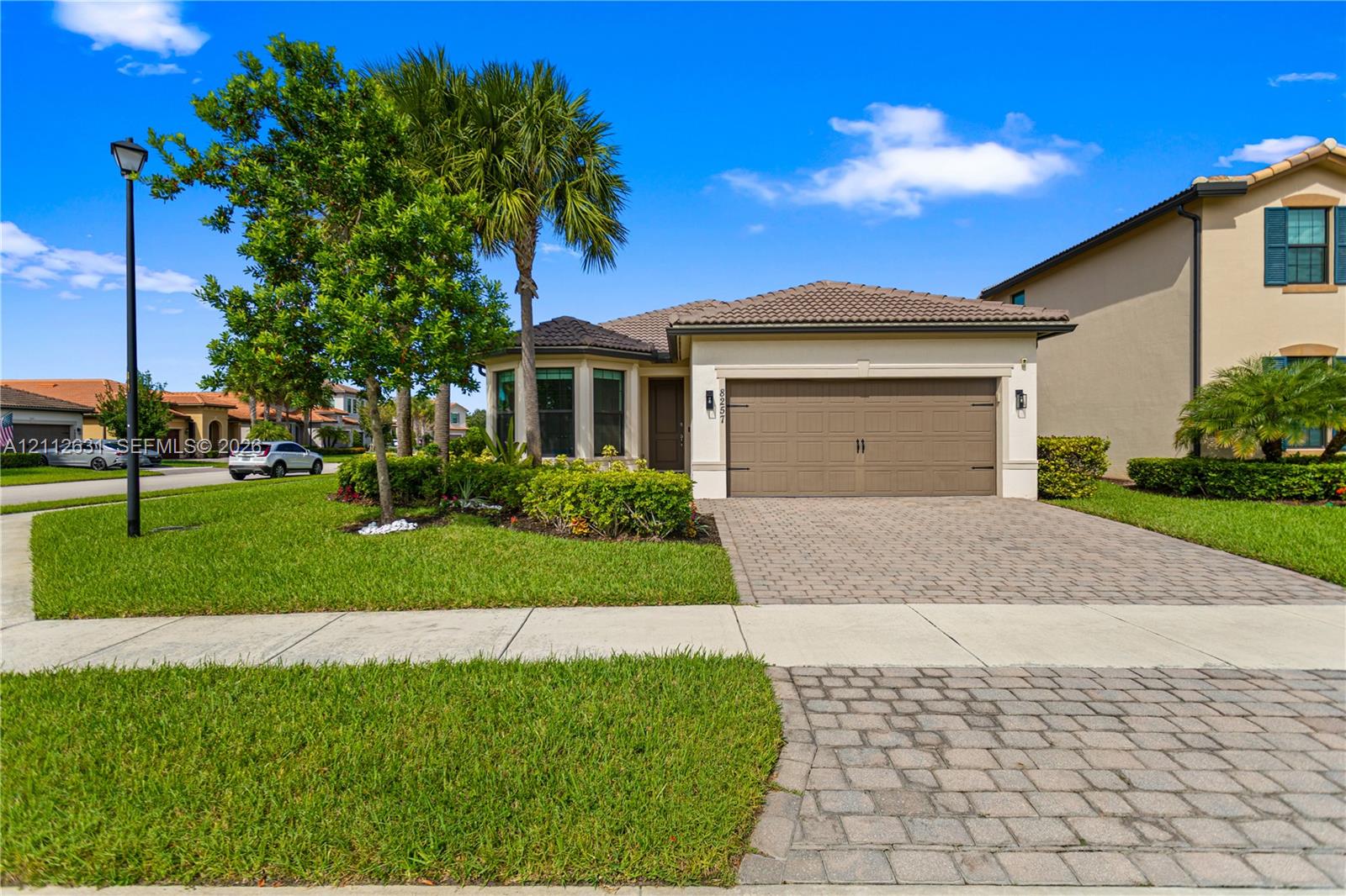 Stucco exterior with a tiled roof, paver driveway, and an attached two-car garage Stucco exterior with a tiled roof, paver driveway, and an attached two-car garage